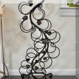 K23. Wrought metal wine holder with leaf decorations. 41.5 ”h x 18”w x 7”d 